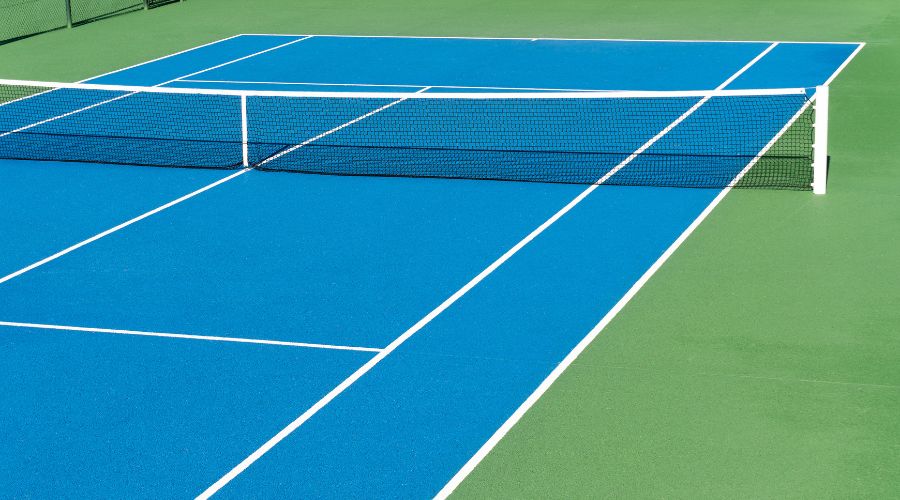 Playing On A Hard Tennis Court